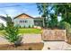 Bungalow exterior with beautiful yard and landscaping, decorative fence, and driveway gate at 853 Gaston Sw St, Atlanta, GA 30310
