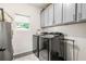 Convenient laundry room with modern washer and dryer, utility sink, and ample storage cabinets at 853 Gaston Sw St, Atlanta, GA 30310