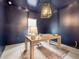 A navy blue office with a neutral colored wooden desk, carpet, and unique lighting fixture at 853 Gaston Sw St, Atlanta, GA 30310