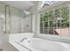 Primary bathroom features a soaking tub with a view of the treelined back yard at 2009 Mclain Nw Rd, Acworth, GA 30101