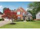 Charming two-story brick home featuring a manicured lawn, mature landscaping, and a three-car garage at 2009 Mclain Nw Rd, Acworth, GA 30101
