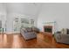 Bright living room featuring hardwood floors, a brick fireplace, and large windows overlooking the backyard at 2009 Mclain Nw Rd, Acworth, GA 30101
