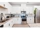 The kitchen features stainless steel appliances, granite countertops, and white cabinets at 320 Crider Ct, Woodstock, GA 30188