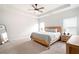 Serene bedroom with a large bed, tray ceiling, ceiling fan, and natural light from windows at 320 Crider Ct, Woodstock, GA 30188