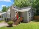 Home featuring neutral siding, a vibrant orange front door, inviting steps, and a neatly landscaped yard at 4679 Candlewyck Way, Buford, GA 30518
