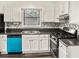 A well-appointed kitchen boasts white cabinets, stainless steel appliances, and a unique backsplash, offering both style and convenience at 4679 Candlewyck Way, Buford, GA 30518