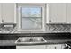 Kitchen features modern appliances, unique backsplash, and a sink with a window above, creating a bright, functional cooking space at 4679 Candlewyck Way, Buford, GA 30518
