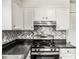 Well-equipped kitchen showcasing white cabinets, stainless steel appliances, and a distinctive backsplash, combining style with practicality at 4679 Candlewyck Way, Buford, GA 30518