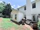 Exterior view of home with an outdoor seating area, back door, and a lush lawn at 49 Hampton Dr, Cartersville, GA 30121