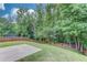 Sloping backyard features a concrete patio and a trampoline with an enclosed wooden fence at 2030 Beyers Landing Dr, Buford, GA 30519