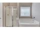 Bathroom featuring a shower, tub, and window bringing in natural light at 2030 Beyers Landing Dr, Buford, GA 30519