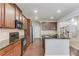 Open kitchen with wood cabinets, black countertops, and stainless steel appliances at 2030 Beyers Landing Dr, Buford, GA 30519