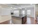 Modern kitchen island with black countertops and stainless steel sink, open to living space at 2030 Beyers Landing Dr, Buford, GA 30519