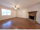 Bright living room featuring hardwood floors, a ceiling fan, and a charming stone fireplace at 294 Spring Leaf Dr, Dallas, GA 30157