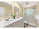 Bright bathroom featuring double sinks, a glass shower and a decorative fern at 440 Barrington W Dr, Roswell, GA 30076