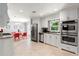 Open kitchen area with modern stainless steel appliances, granite countertops, and eat-in dining space at 440 Barrington W Dr, Roswell, GA 30076
