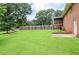 Large backyard featuring a well-maintained lawn, wooden fence, brick patio, and screened in porch at 879 Old Tucker Rd, Stone Mountain, GA 30087