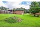 Expansive backyard featuring lush lawn, mature trees, a privacy fence, and brick details at 879 Old Tucker Rd, Stone Mountain, GA 30087