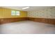 Large unfinished basement featuring paneled walls, unique wallpaper, and a window to let in natural light at 879 Old Tucker Rd, Stone Mountain, GA 30087