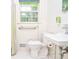 Bright bathroom featuring neutral finishes, a sink, and a toilet next to the tub with a shower at 879 Old Tucker Rd, Stone Mountain, GA 30087