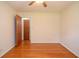 Modest bedroom featuring hardwood floors, neutral-toned walls, and a door leading to another room at 879 Old Tucker Rd, Stone Mountain, GA 30087