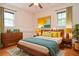 Staged bedroom featuring a bed with a teal blanket, nightstands, and a dresser with modern decor at 879 Old Tucker Rd, Stone Mountain, GA 30087