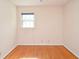 Empty bedroom featuring hardwood floors, neutral-toned walls, and a window for lots of natural light at 879 Old Tucker Rd, Stone Mountain, GA 30087