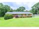 Charming one-story brick home with a well-manicured lawn, shrubs and black shutters at 879 Old Tucker Rd, Stone Mountain, GA 30087