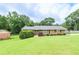 Charming brick home with a well-manicured lawn, mature shrubs, and a welcoming front entrance at 879 Old Tucker Rd, Stone Mountain, GA 30087