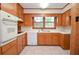 Functional kitchen with wood cabinets, white appliances, tile countertops, and neutral flooring at 879 Old Tucker Rd, Stone Mountain, GA 30087