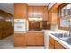 Classic kitchen with wooden cabinets, white appliances, tile countertops, and a window over the sink at 879 Old Tucker Rd, Stone Mountain, GA 30087
