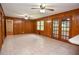Large living room with tile floors, wood paneling, access to patio through glass doors, and a wet bar at 879 Old Tucker Rd, Stone Mountain, GA 30087
