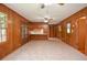 Spacious living room with tile floors, wood paneled walls, ceiling fan, and access to kitchen at 879 Old Tucker Rd, Stone Mountain, GA 30087