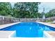 Wide view of a large rectangular swimming pool with outdoor lounge chairs and dining area at 879 Old Tucker Rd, Stone Mountain, GA 30087