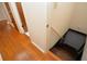 Hallway with hardwood floors leading to the basement stairs with a handrail for safety at 879 Old Tucker Rd, Stone Mountain, GA 30087