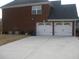 Rear view of a brick house showing a two-car garage and driveway at 989 Park Knoll Ct, Lawrenceville, GA 30043