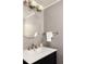 Chic bathroom features a black vanity, round mirror, and modern lighting fixtures with a white sink at 1392 Cornwall Rd, Decatur, GA 30032