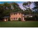 Beautiful two-story brick home with manicured lawn and mature trees providing shade and privacy at 1392 Cornwall Rd, Decatur, GA 30032