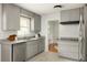 Modern kitchen with stainless steel appliances, gray cabinetry, and an open view to the dining room at 1392 Cornwall Rd, Decatur, GA 30032