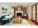 Inviting living room with brick fireplace, wooden coffee table, hardwood floors, and ample natural light at 1392 Cornwall Rd, Decatur, GA 30032