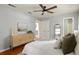 Bright main bedroom featuring a ceiling fan, hardwood floors, and ensuite bathroom at 1392 Cornwall Rd, Decatur, GA 30032