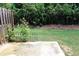 Backyard featuring a concrete patio, wooden fence, and lush greenery at 1783 Shetley Creek Drive, Norcross, GA 30071
