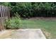 View of the yard with a small concrete patio area, lush green lawn, and a wooden privacy fence at 1783 Shetley Creek Drive, Norcross, GA 30071