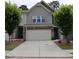Two-story townhome with a stone facade, attached two-car garage, and a well-manicured lawn at 1783 Shetley Creek Drive, Norcross, GA 30071