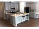 Charming kitchen features gray cabinets, stainless steel appliances, and a large island with bar stool seating at 1783 Shetley Creek Drive, Norcross, GA 30071