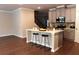 Kitchen island with bar stool seating, stainless steel appliances, and open access to living area at 1783 Shetley Creek Drive, Norcross, GA 30071