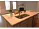 This kitchen island has a light countertop, cabinets, stainless steel sink, and stainless steel dishwasher at 1783 Shetley Creek Drive, Norcross, GA 30071