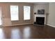 The living room features a fireplace, two windows, wood flooring, and neutral paint at 1783 Shetley Creek Drive, Norcross, GA 30071