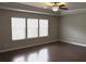 This main bedroom has hard wood flooring, a ceiling fan, and three windows for natural light at 1783 Shetley Creek Drive, Norcross, GA 30071