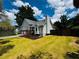 Expansive backyard featuring a well-maintained lawn and mature trees under a blue sky with white clouds at 208 Arbour Way, Suwanee, GA 30024